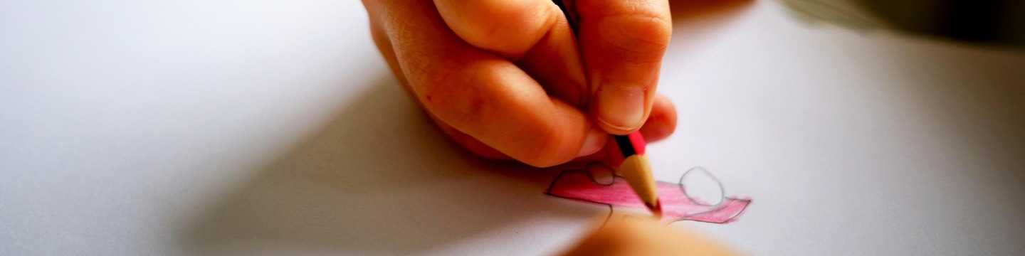 Kinderhand tekent roze auto op wit papier